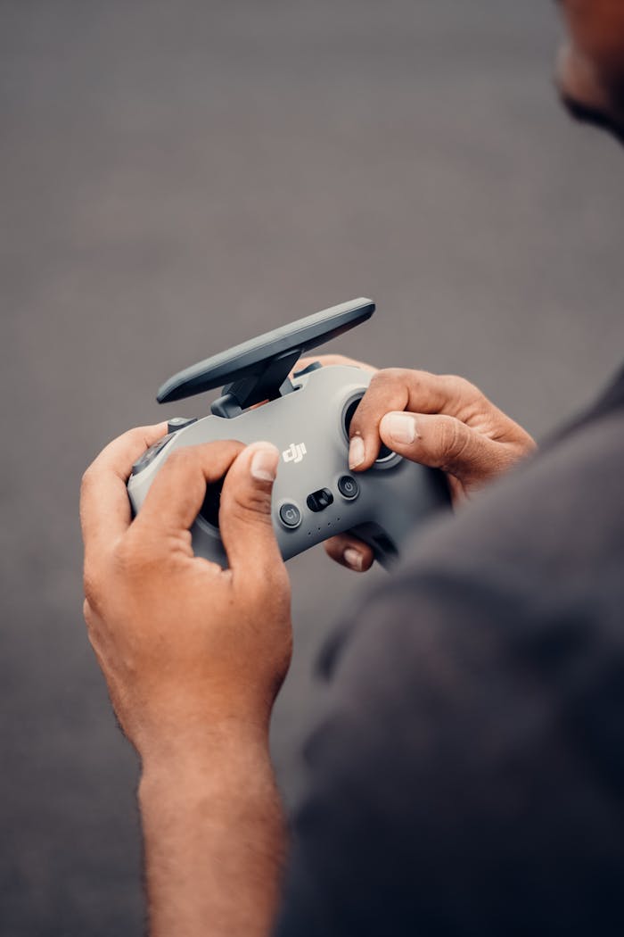 about-01 Hands holding a drone controller with focus on touch and technology in an outdoor setting.
