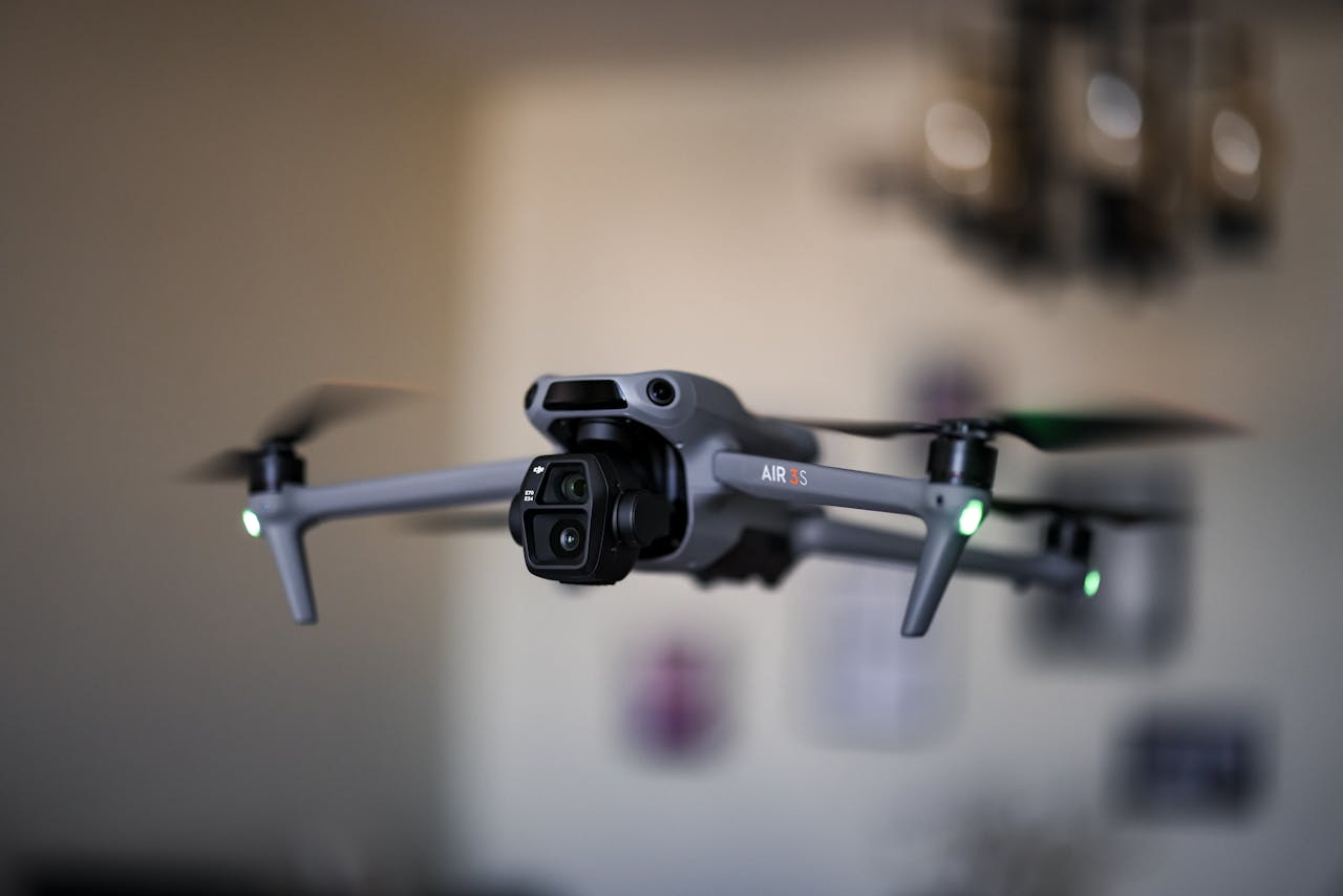 why-choose-us A high-tech drone flying indoors with propellers spinning rapidly, showcasing advanced technology.