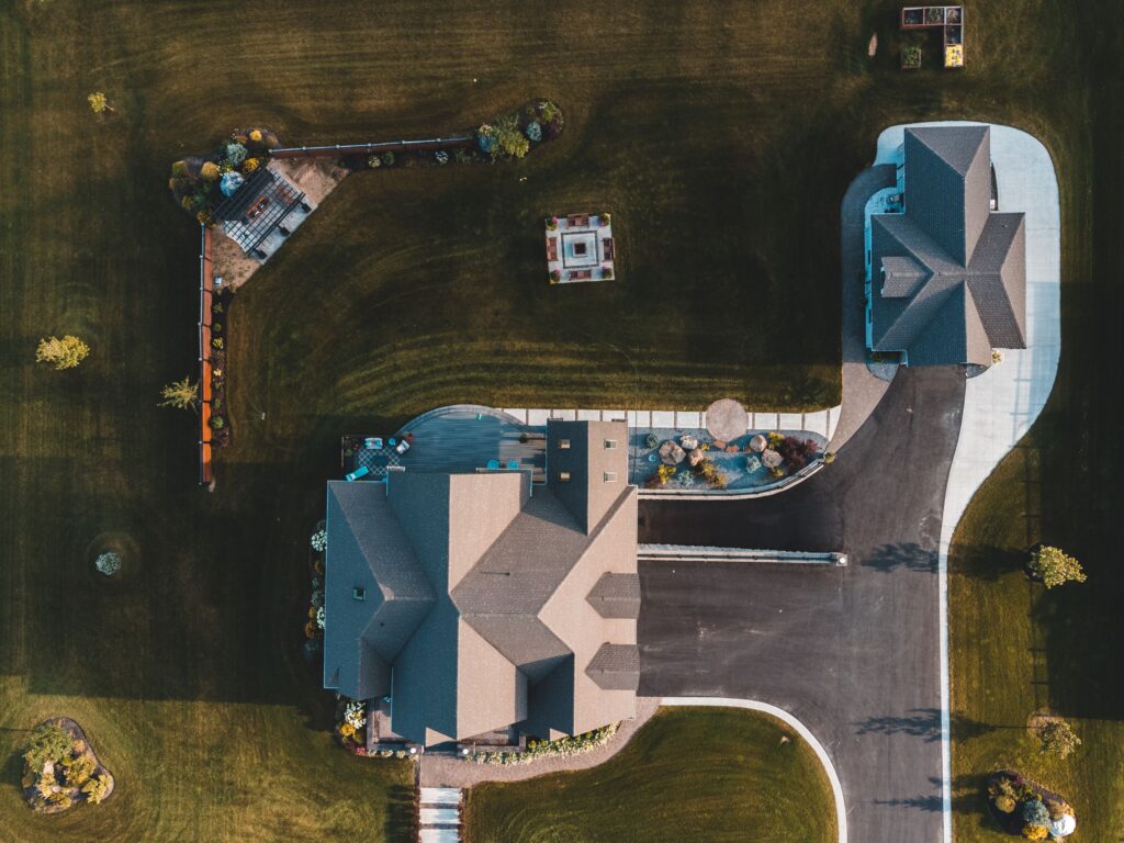 pexels photo 9203785 9203785 Drone view of suburban neighborhood with houses, driveways, and landscaped gardens.